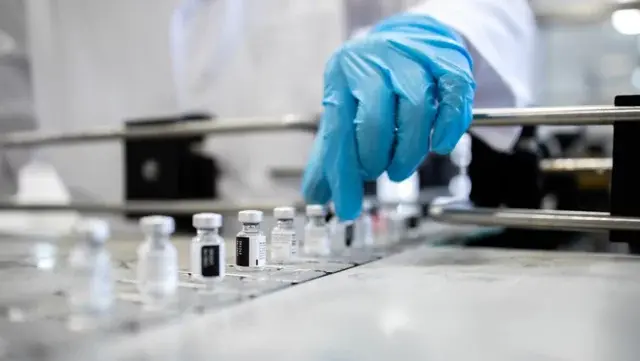 Pharmaceutical factory and industrial mass production of vaccine bottles against Covid-19 or corona virus pandemic.